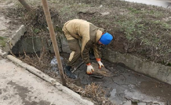 Рабочий чистит ливнёвку. Фото пресс-службы администрации Новочеркасска