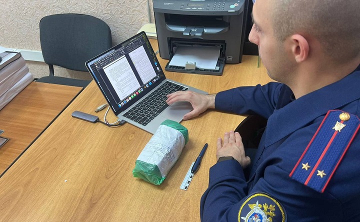 Сотрудник СК с изъятыми у преступников деньгами. Фото пресс-службы СК